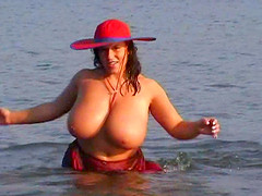 Chubby cougar with huge natural tits touching her hot body on the beach