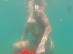 Blonde Ann Joy wearing a red bikini having fun in the sea