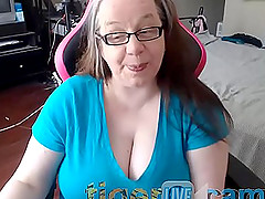 Mature nerdy MILF exposes her huge natural tits on a chair